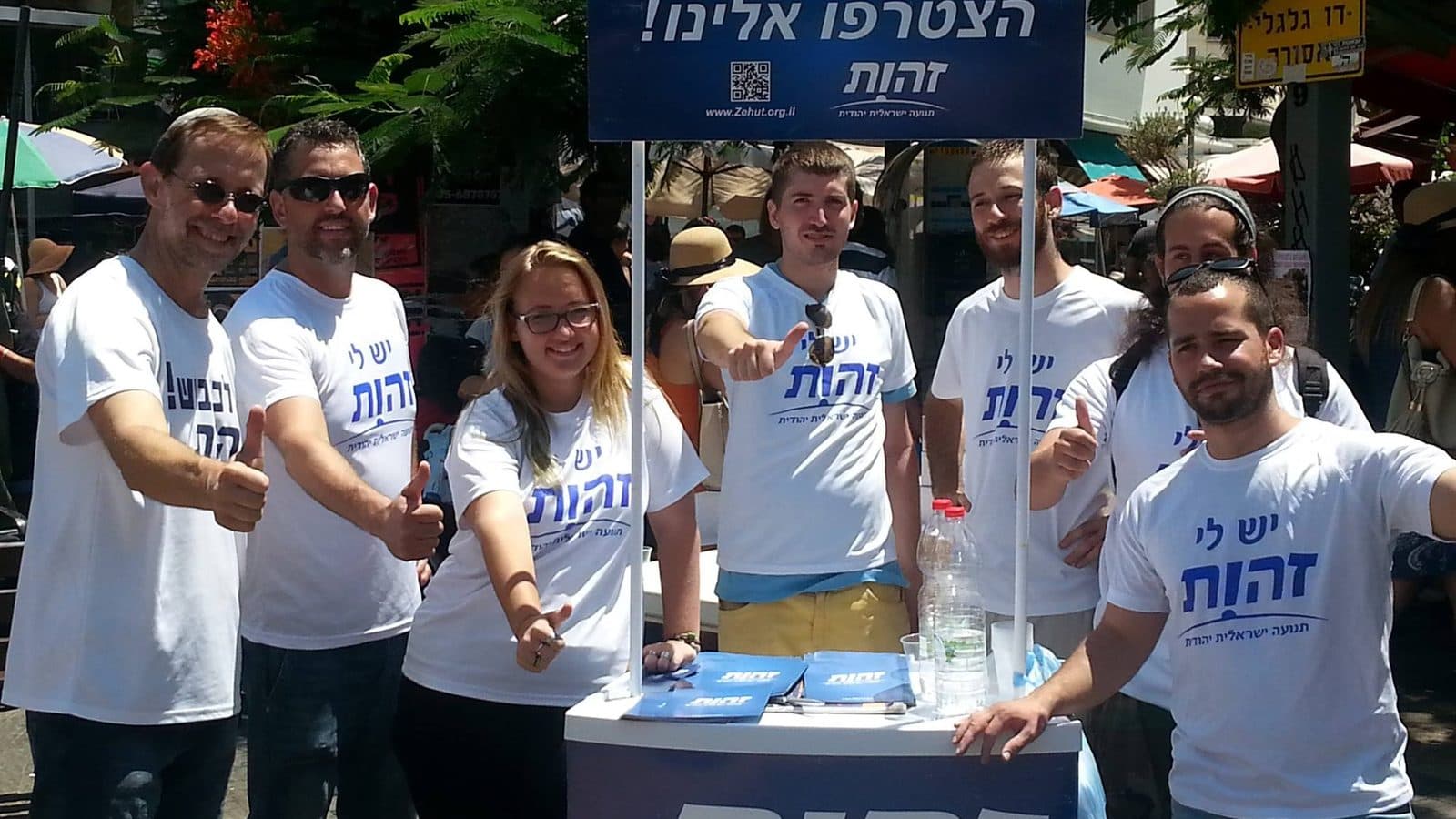 פעילי שטח של זהות בדוכן רחוב, לבושים בחולצות התנועה — פעילות בשטח